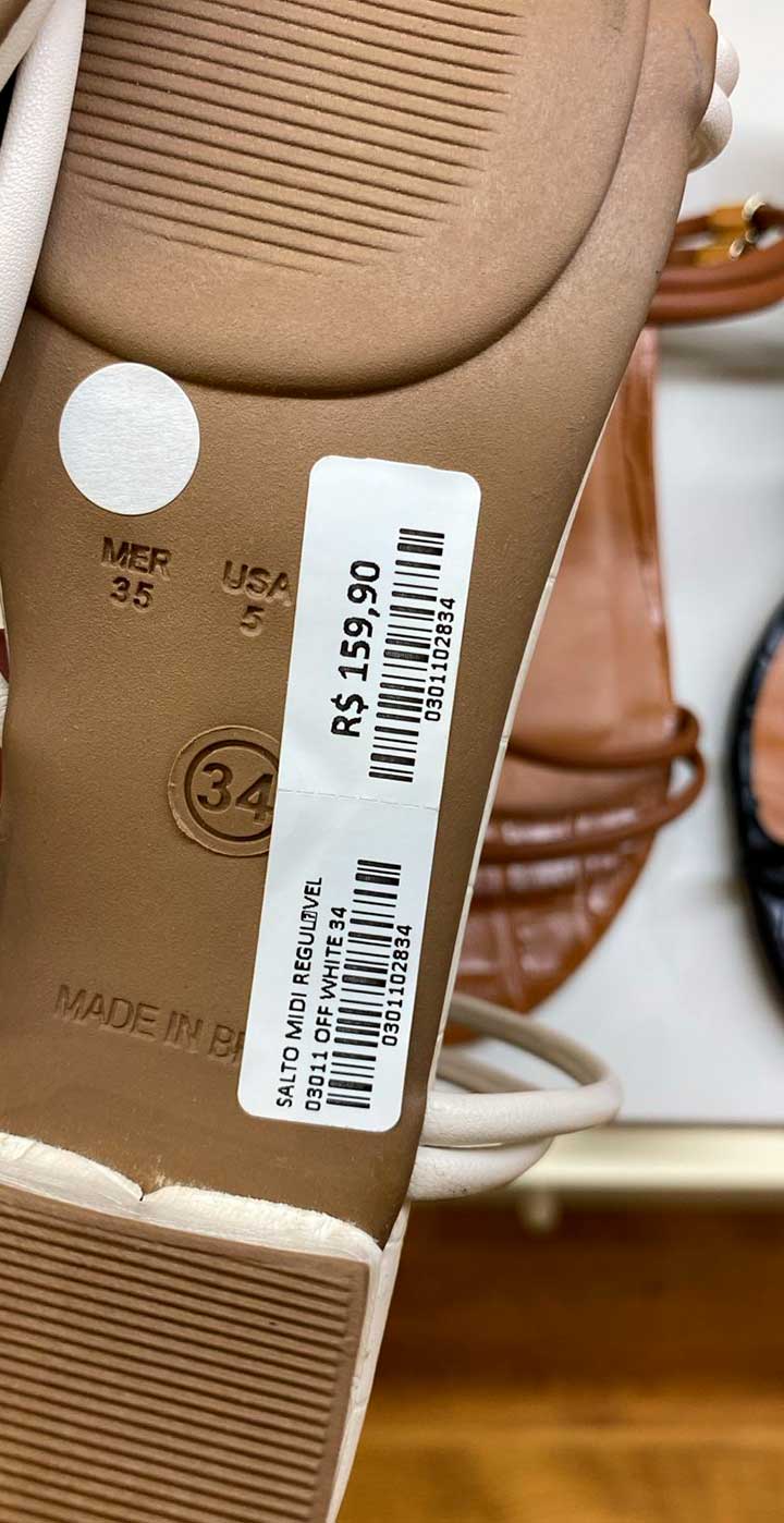 Verso de um sapato com etiqueta colada com informações do produto, pronto para escanear